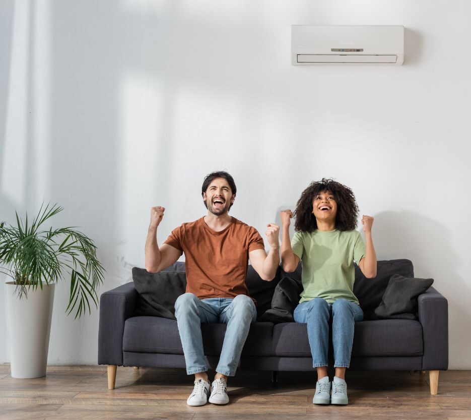 happy couple on couch wall hvac unit